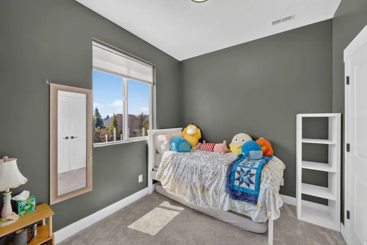 Carpeted room featuring a large window with blinds, a built-in closet with white paneled doors, and a recessed ceiling light