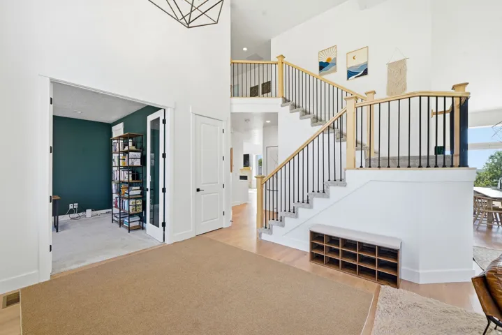 Two-story foyer with a staircase featuring wood newel posts and black metal balusters
