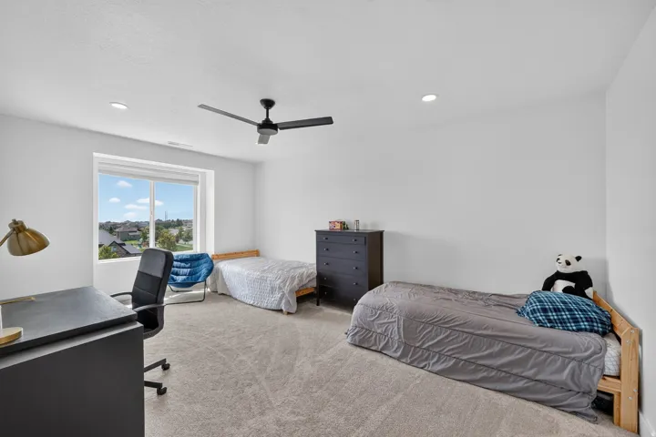 Recessed lighting, ceiling fan, expansive window, neutral carpeting, and white wall finishes
