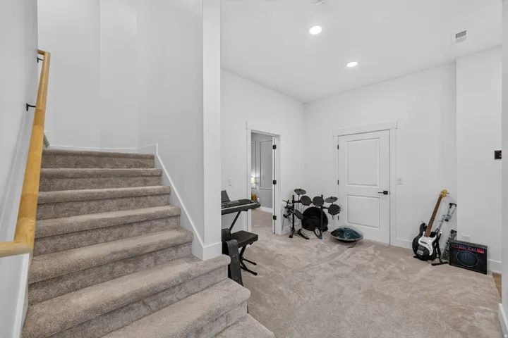 Carpeted staircase with a wood handrail