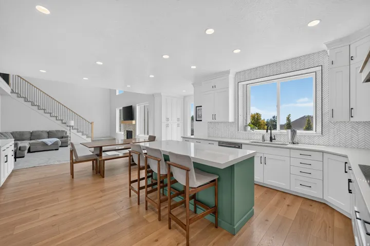 Open-concept kitchen featuring an island with a white countertop and contrasting green base