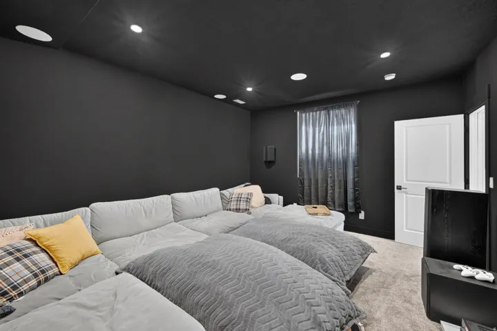 Recessed lighting, dark wall finishes, dark ceiling, window with curtain, white door