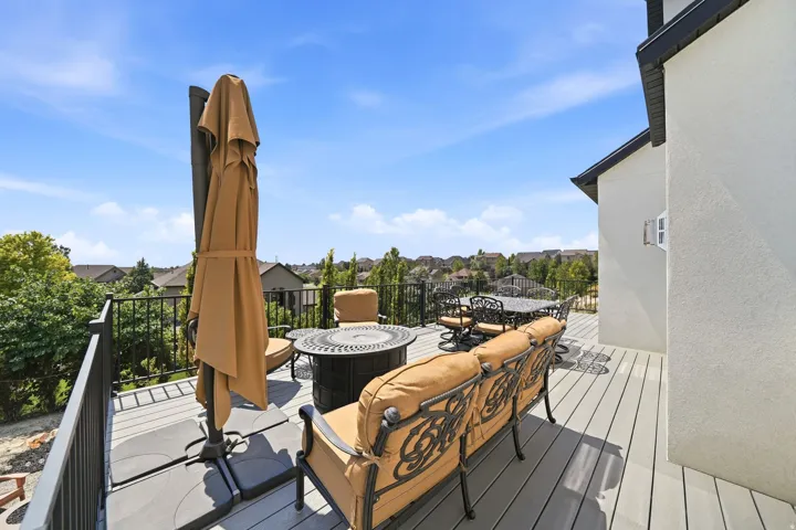 Composite decking with black metal railing and a stucco exterior