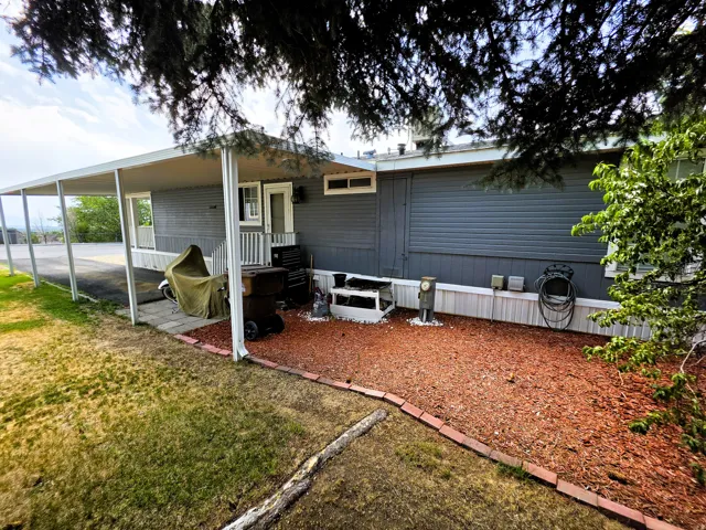 Carport structure, Hardie board siding exterior, red bark ground cover, full landscaping