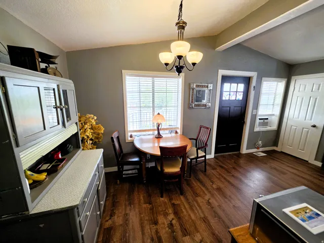 Wood-finish flooring, vaulted ceiling, and an updated chandelier