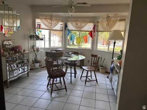 Tile flooring throughout with multiple windows and a ceiling fan