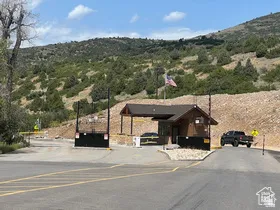 Gated entry with a guardhouse, covered canopy, and paved access roads