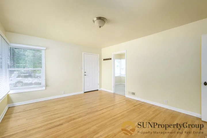 Hardwood flooring, painted walls, white trim, recessed lighting, and a paneled door