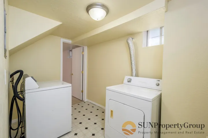 Utility room featuring patterned floor tile, a ceiling-mounted light fixture, and a compact window