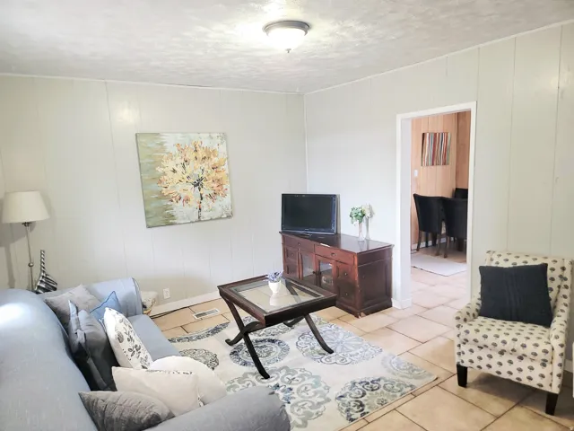 Recessed lighting, light-toned wall paneling, tiled flooring, open doorway