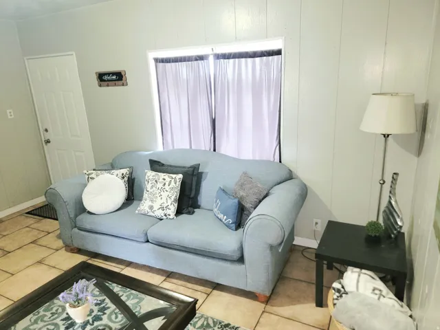 Tile flooring, white paneled walls, white interior door, and a built-in window