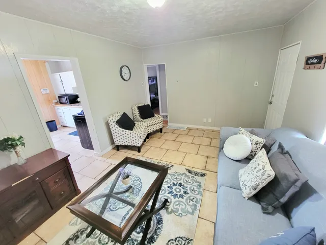 Neutral wall paneling, tile flooring, and white trim accents