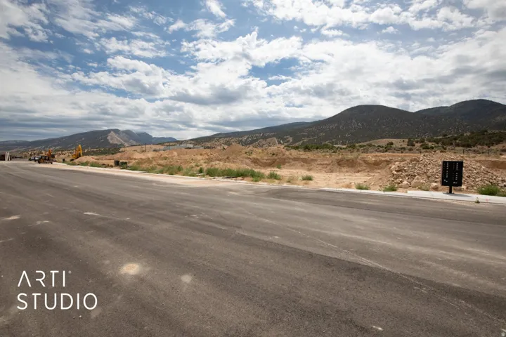 Roadside property with a natural mountain backdrop and clear sky