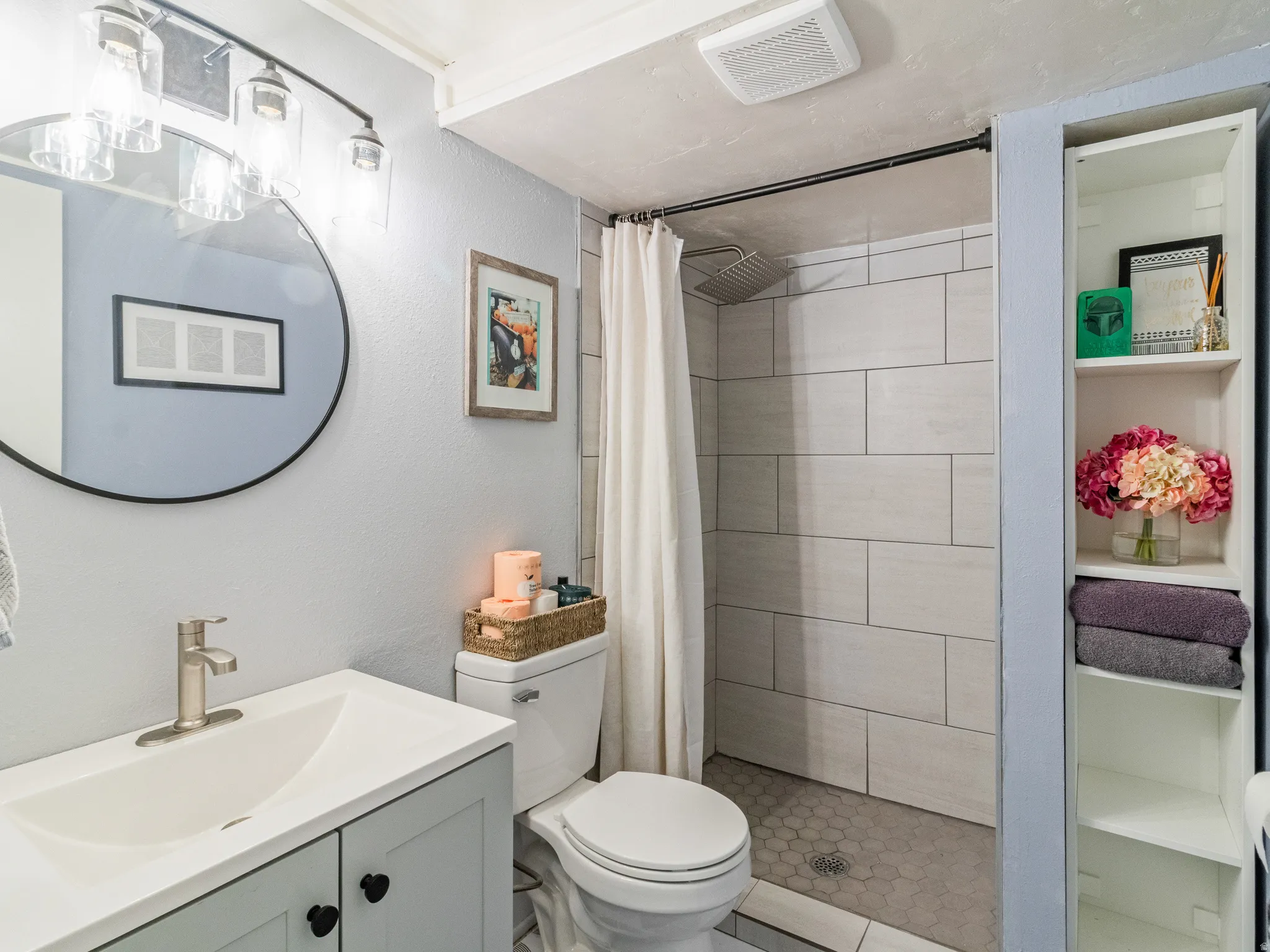 Shower with light-toned rectangular wall tiles and hexagonal floor tiles
