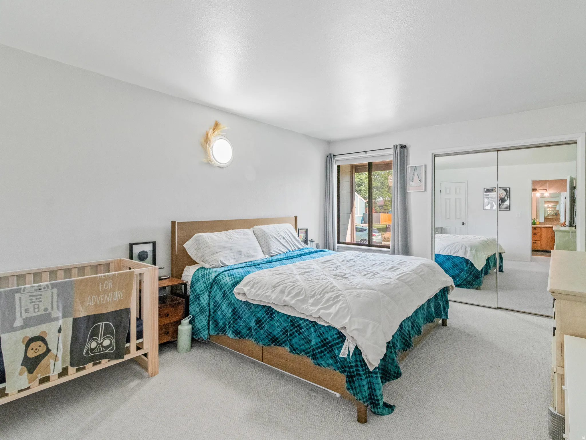 Wall-to-wall carpeting, window with drapery, and mirrored closet doors