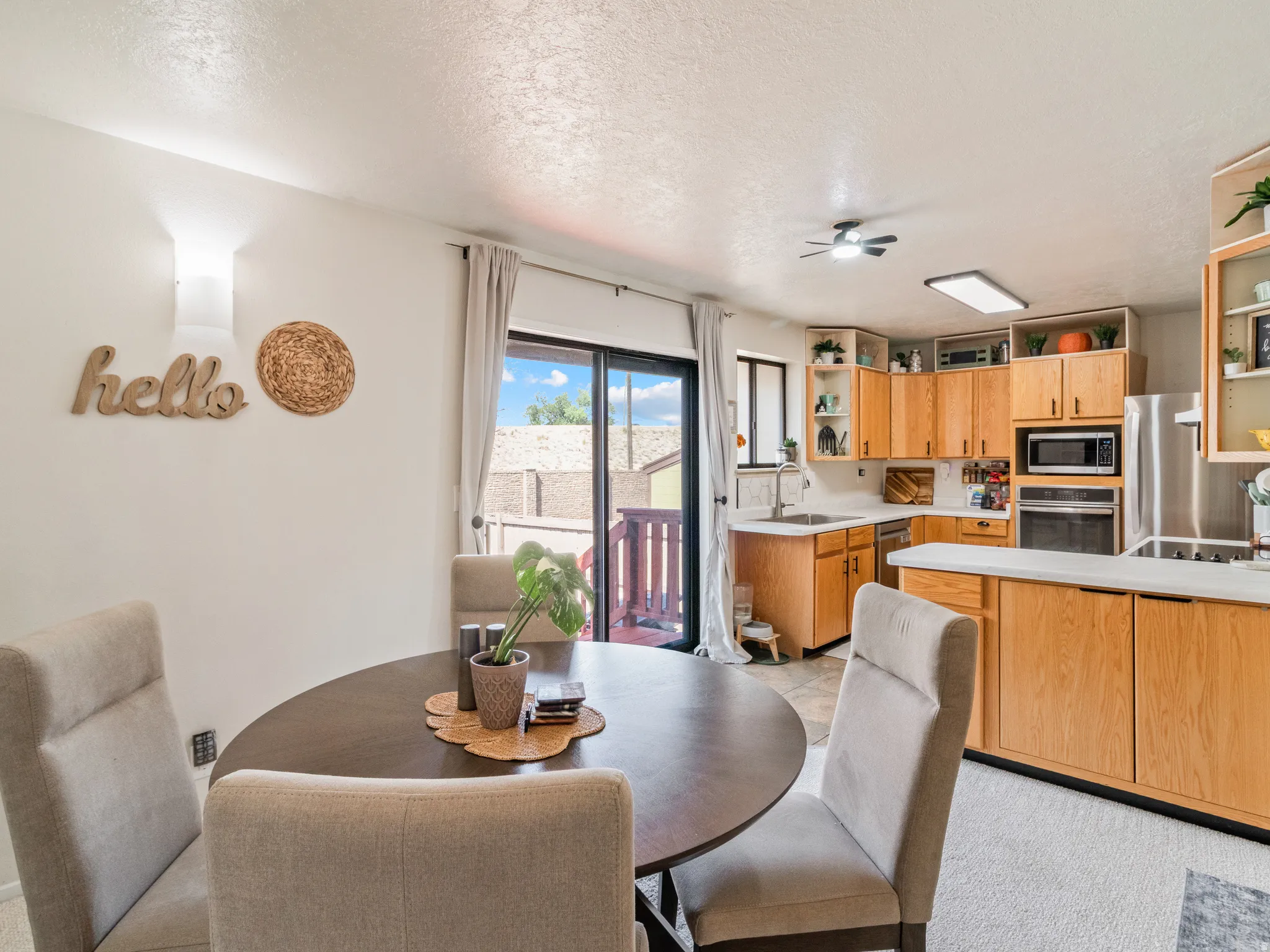 Kitchen with wood-finish cabinetry, stainless steel appliances, and light-colored countertops
