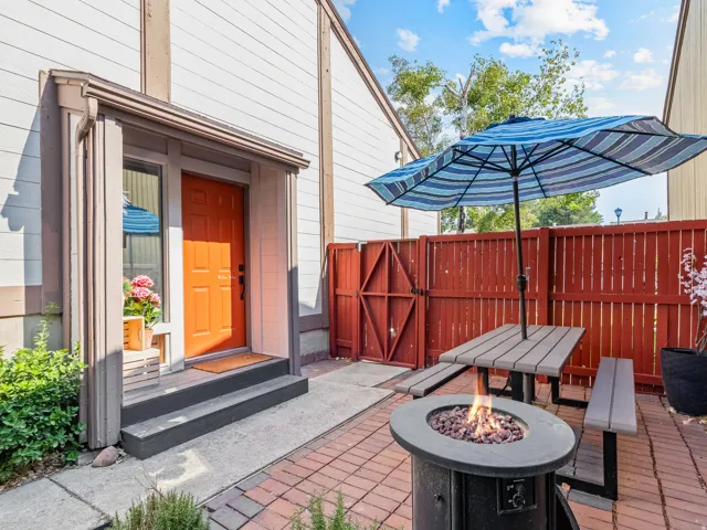Brick paver patio, wood privacy fence, entry door with sidelight, exterior fire pit, and durable siding