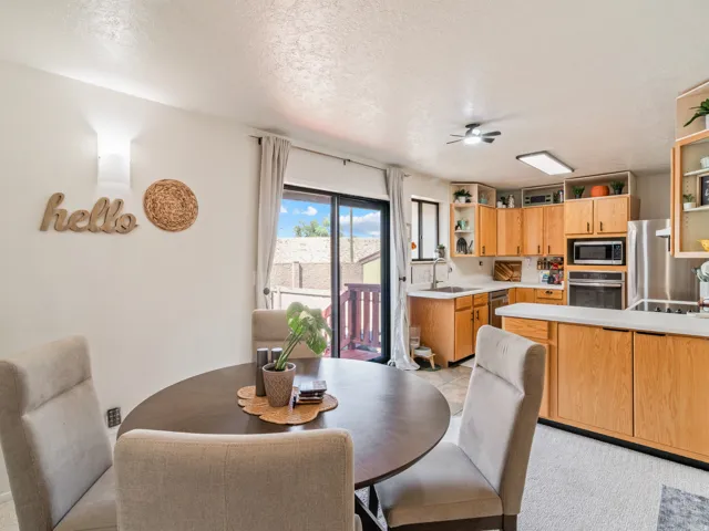Kitchen with wood-finish cabinetry, stainless steel appliances, and light-colored countertops