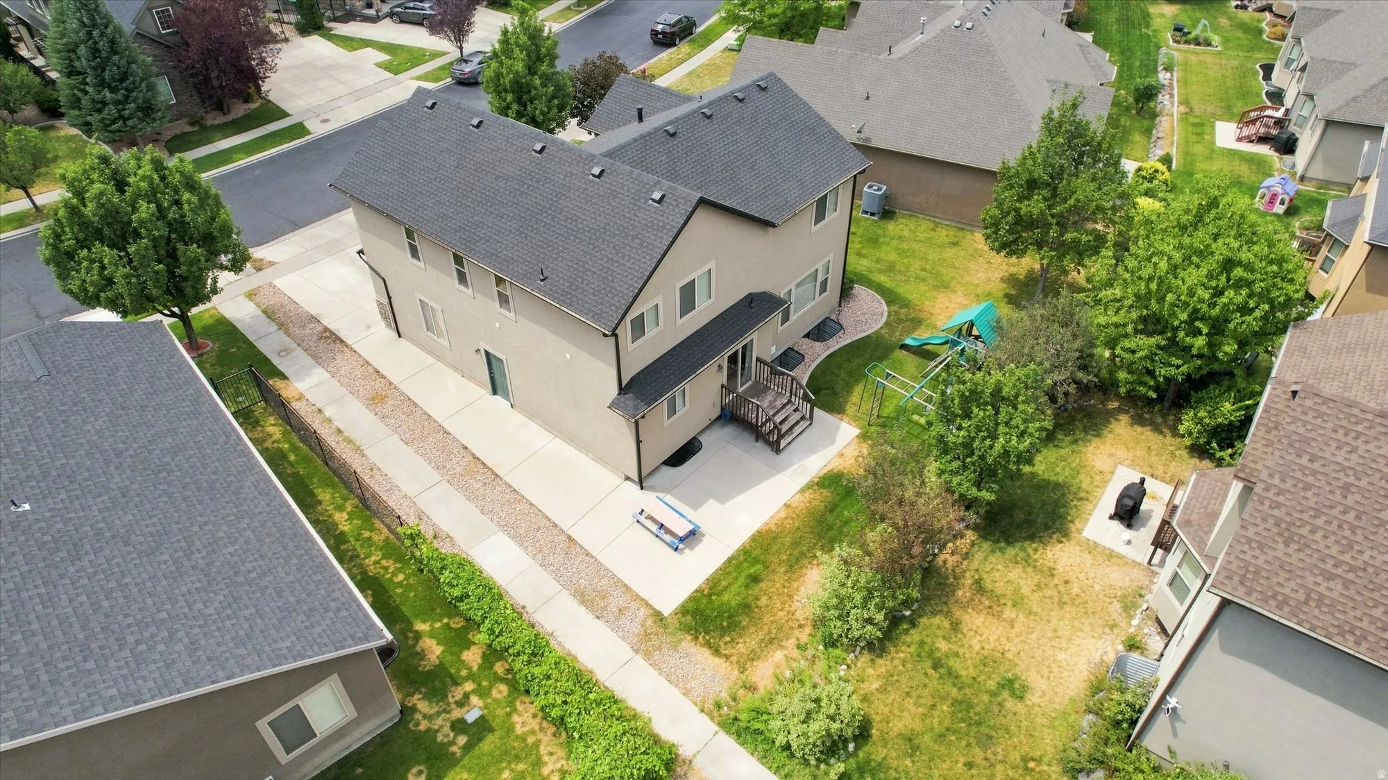Two-story residence with a dark shingle roof and light-colored siding