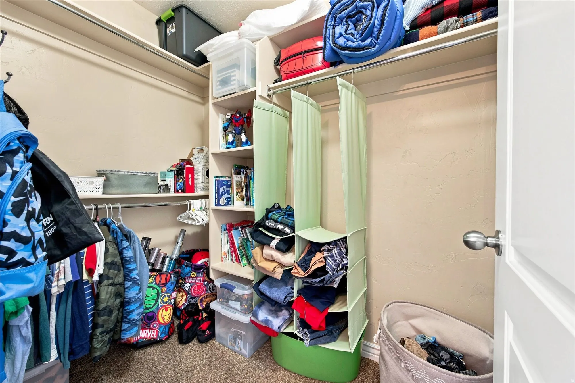 Walk in closet Built-in closet shelving, hanging rods, and carpeting