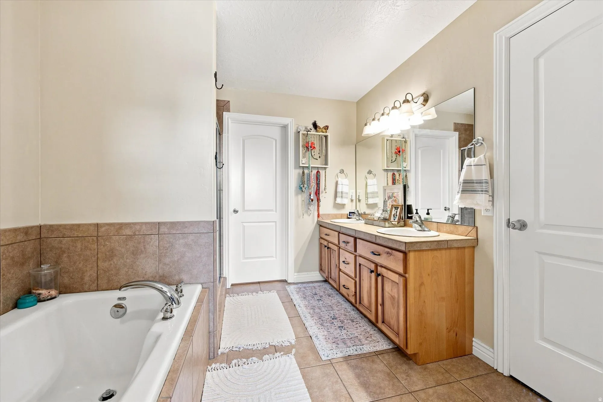 Primary bedroom ensuite bathroom with separate tub and shower Tiled flooring throughout
