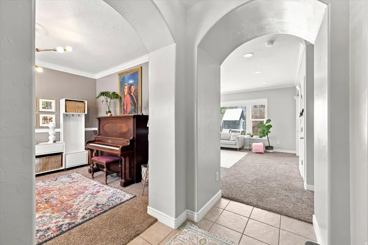 Archway entry with tile flooring transitioning to carpet