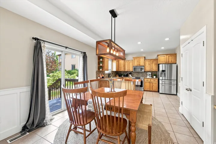 Sliding glass door, wood-finish cabinetry, stainless steel appliances, tile flooring, recessed lighting