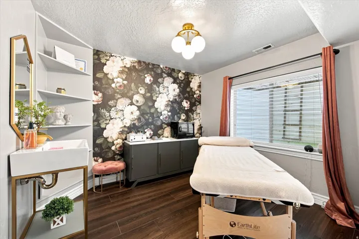 Spa room with sink Wood-finish flooring with a floral accent wall