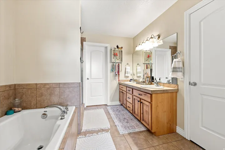Primary bedroom ensuite bathroom with separate tub and shower Tiled flooring throughout