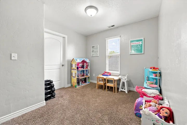 Upstairs loft, Textured walls, arched interior door, single window with blinds, recessed ceiling light, and carpet flooring
