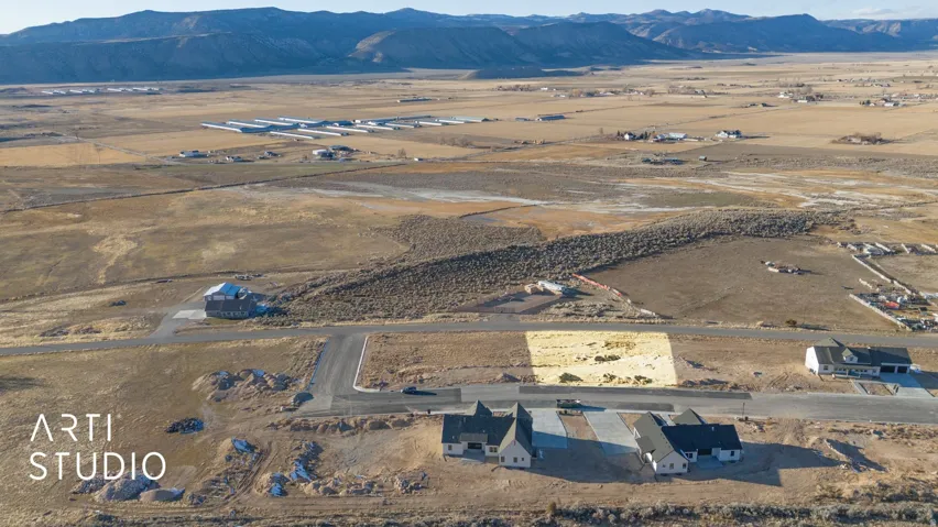 Expansive land parcel with surrounding mountain scenery and established roadways