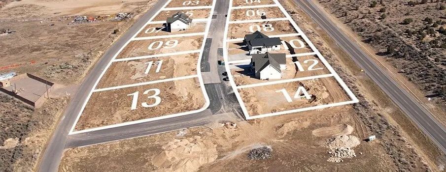Residential development with numbered lots, paved roads, and single-story homes