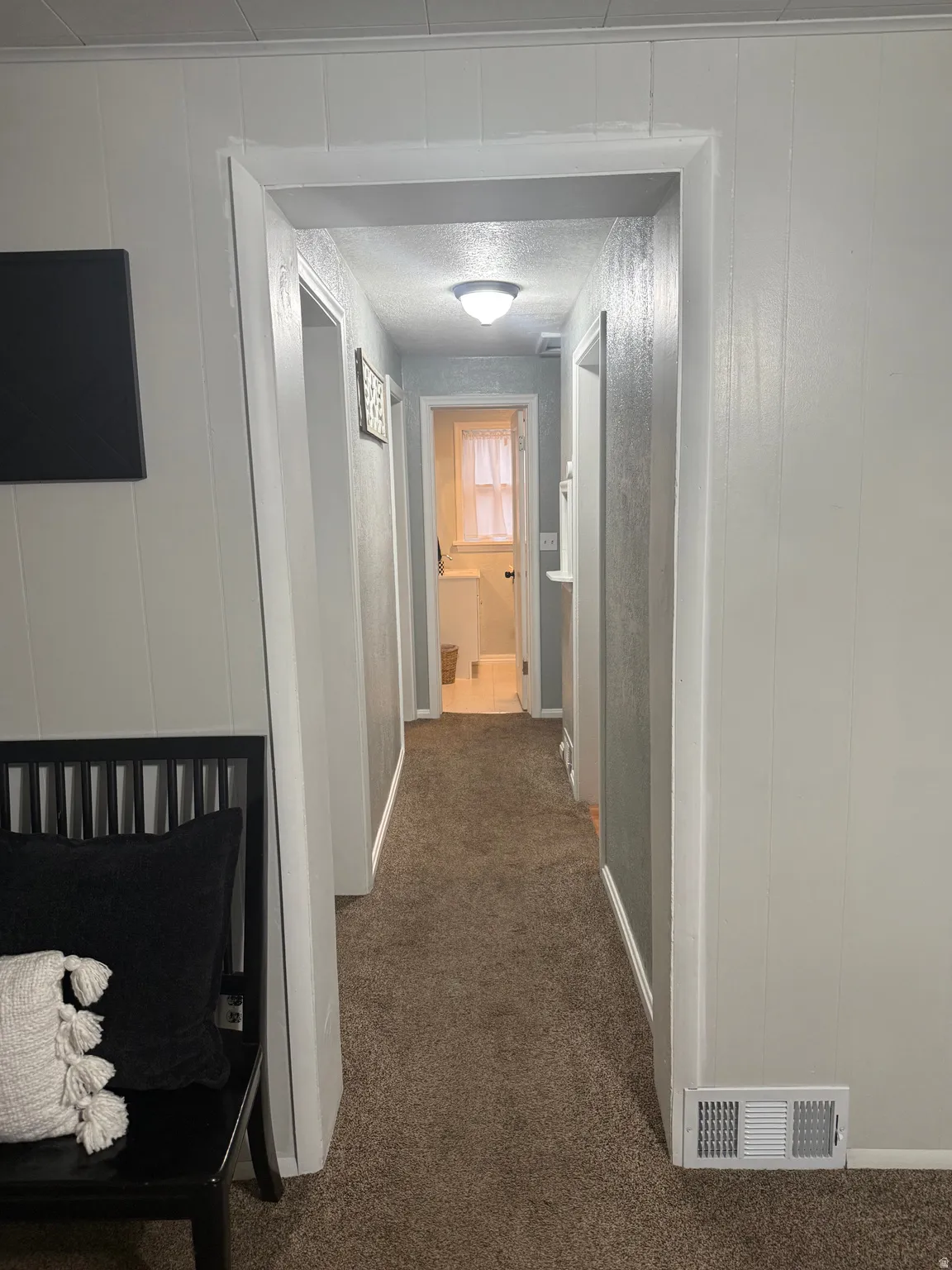 Hallway featuring neutral-toned carpeting and overhead lighting