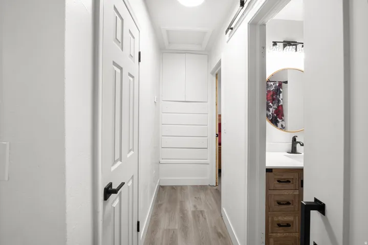 Hallway featuring wood-finish flooring and built-in cabinetry