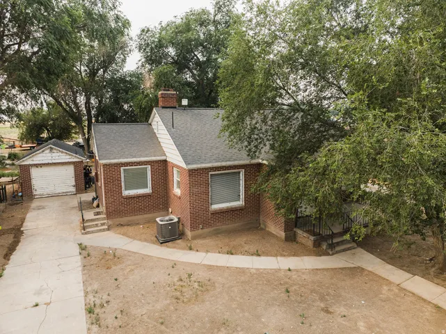 Brick exterior residence featuring a detached garage, a concrete driveway, and a walkway leading to the front entry