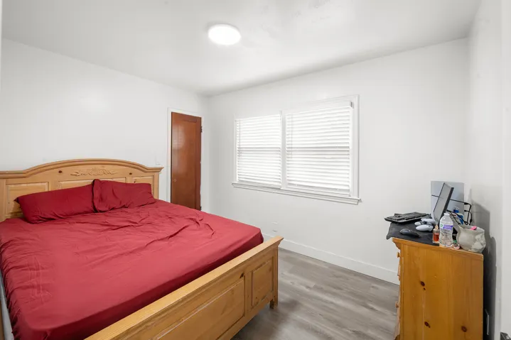 White walls, wood-finish flooring, and white window blinds