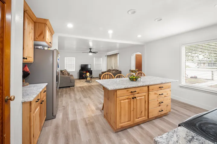 Kitchen featuring an island with stone countertops, wood cabinetry, and recessed lighting