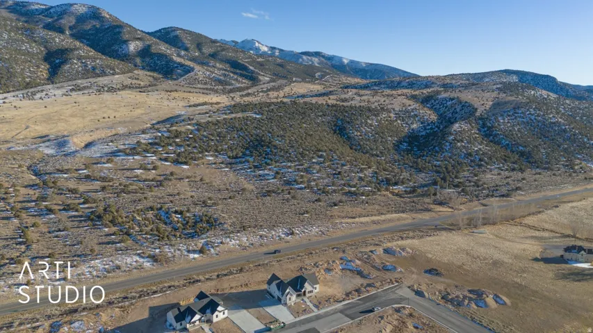 New construction properties with paved driveways and mountain scenery
