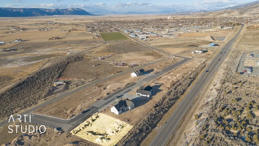 Expansive rural setting with mountain backdrop, established road infrastructure, and multiple newly constructed homes