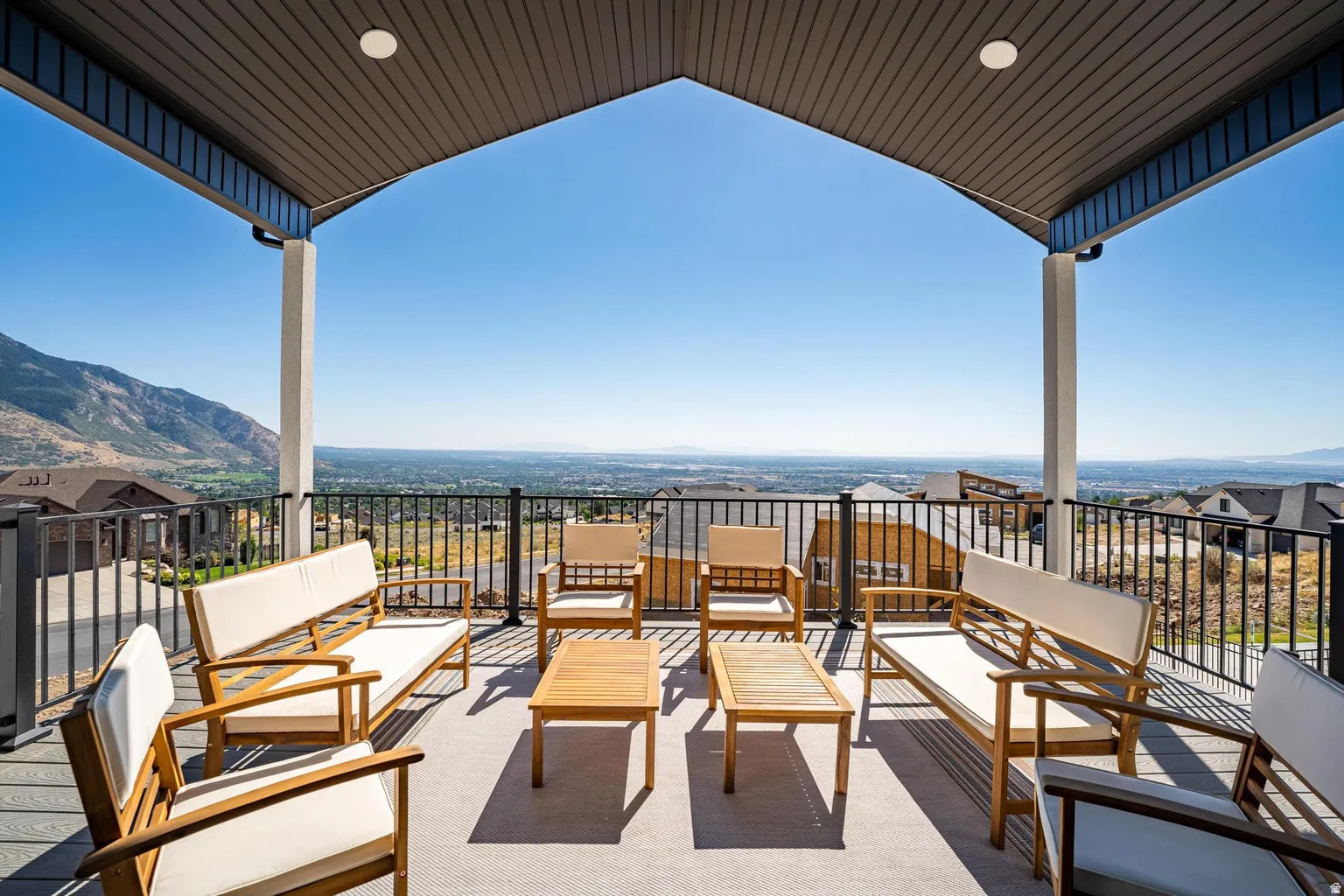 Covered outdoor deck with composite decking, recessed lighting, and metal railings