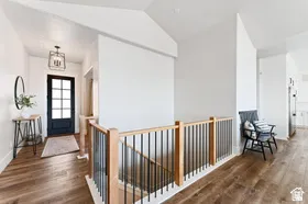 Entryway featuring a dark paneled door, wood-finish flooring, and a modern light fixture