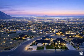 Expansive neighborhood with widespread residential lighting and surrounding natural terrain