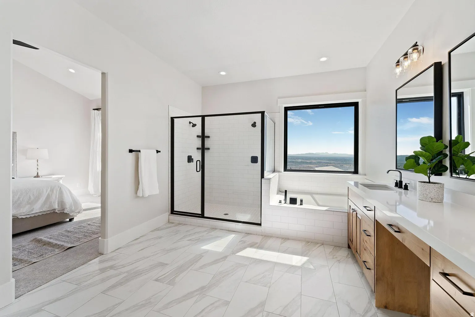 Spacious bath featuring marble-look tile flooring, a large soaking tub with tile surround, and a glass-enclosed shower with subway tile