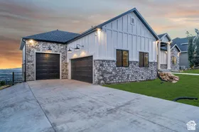 Stone and vertical siding exterior with two garage doors
