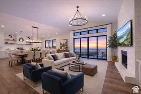 Expansive living area with large format sliding glass doors, a modern fireplace, wood-finish flooring, and recessed lighting