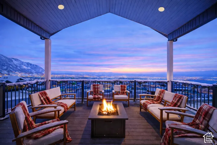 Expansive covered deck featuring a built-in fire pit, composite decking, and a metal railing system