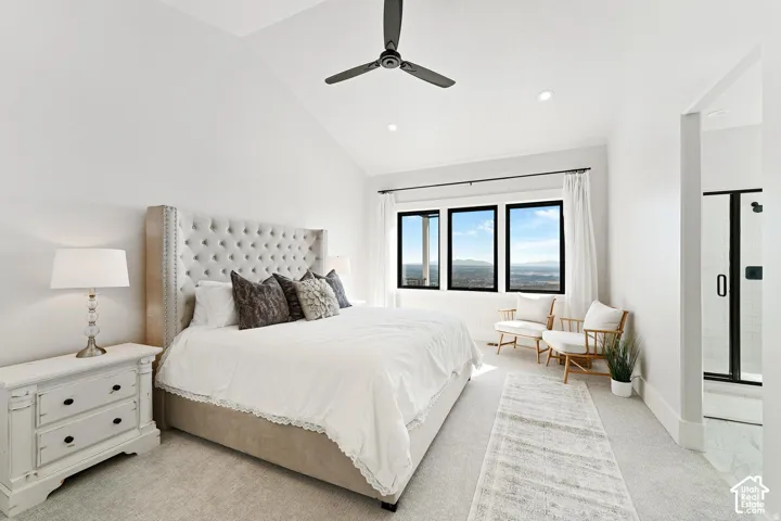 Bright primary bedroom featuring a tufted upholstered headboard, recessed ceiling lighting, ceiling fan, and triple casement windows flooding the space with natural light