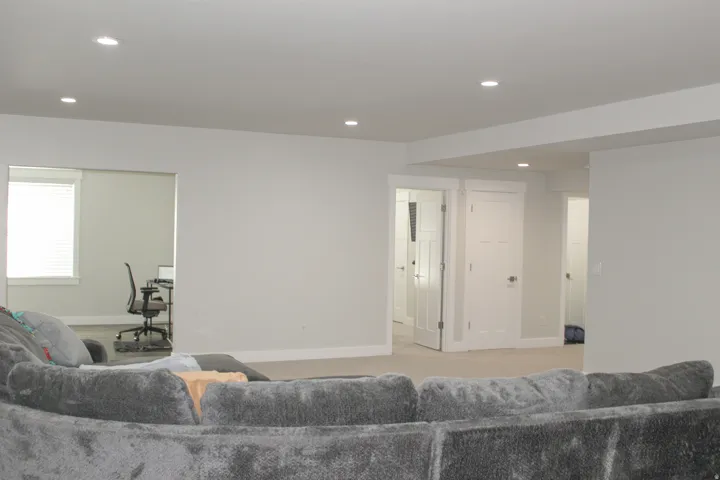 Recessed lighting, light gray wall paint, white trim, light-colored carpet, and interior doors with brushed nickel hardware