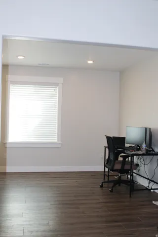 Recessed ceiling lighting, wood-finish flooring, and a large window with white blinds