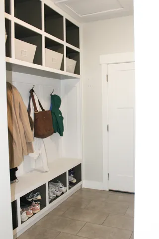 Built-in mudroom storage with open shelving, integrated bench seating, and dedicated shoe cubbies